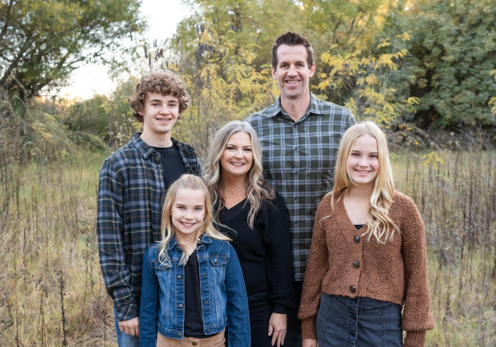 Kari Watt, an elementary teacher at Compass Online for six years, smiles with her family on a beautiful autumn day.