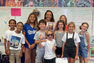 Group of smiling scholars pose in classroom