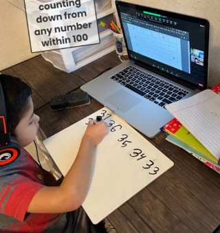 Scholar sits at his desk and writes numbers with a black pen